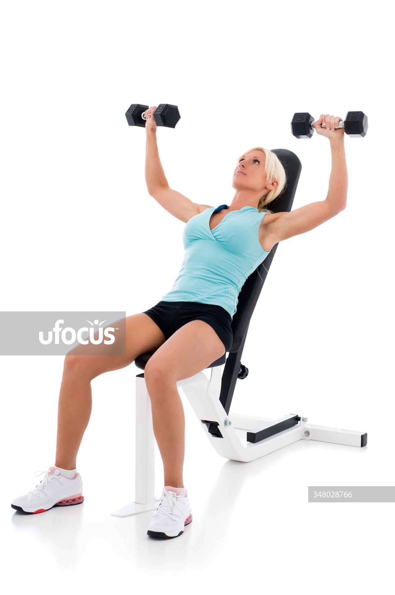 Fit woman lifting weights on weight bench stock photo