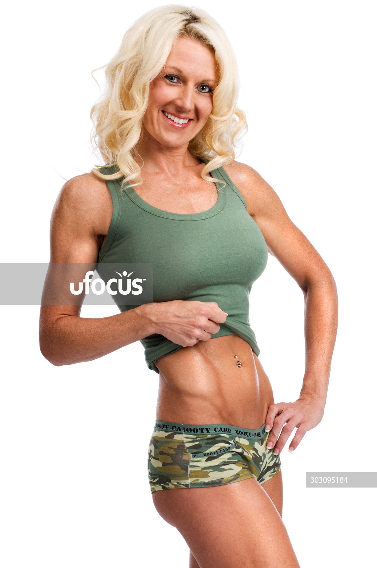 Smiling happy fit woman showing her muscles stock photo