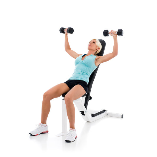 Fit woman lifting weights on weight bench stock photo